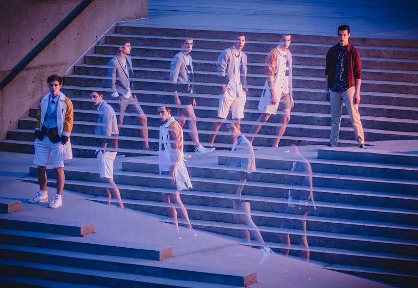 Multiple-exposure menswear image, models descending concrete steps in blue light